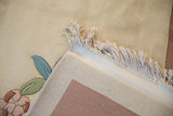 Cream fringe and hand knotted reverse of Art Deco rug with carved floral design.