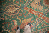 Vintage Indian Caucasian design rug showcasing emerald green field and terracotta, dusty blue floral arabesques.
