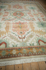 Vintage Indian Caucasian carpet detail: blush palmettes, jade laurel leaves, geometric border, fringe.