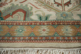 Vintage Indian carpet with geometric border in gold, jade green, terracotta, and ivory fringe.