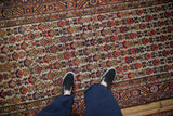 Overhead view of a vintage Hamadan runner's varied pile and dense, geometric floral pattern.