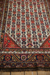 Detailed floral and serrated leaf main border on a textured vintage Hamadan rug runner.