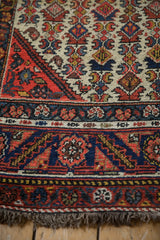 Corner view of a vintage Hamadan runner showing the detailed floral border and short, secured end fringe.