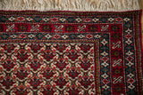 Corner view of the fine Ardebil rug's full pile, intricate floral borders, and clean ivory fringe.