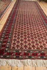 Angled view of the fine Ardebil runner, showing the full length of its cherry red and ivory lattice pattern.