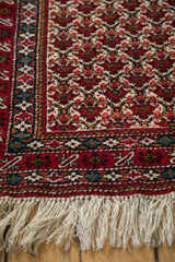 Intricate floral border and ivory fringe on a vintage Ardebil runner with a dense, full wool pile.