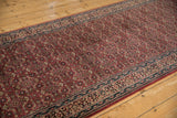 Intricate Herati mahi-mahi floral pattern on dark cochineal red field with navy border.