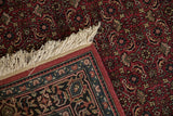 Folded corner of the Indian Bijar runner, showing fringe and Herati mahi-mahi design in rich red.