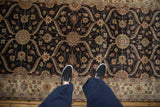 Overhead view of a Mogul rug's charcoal field with a scrolling silver and sand trellis pattern.