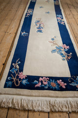 Chinese Art Deco runner's cobalt blue border, pink floral spray, blue butterfly, and ivory fringe.