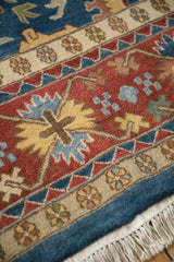 Hand-knotted Indian Bijar rug detail: sky blue, brick red borders, saffron floral motifs, and fringe.