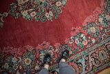 Close view of a vintage Arak's ruby red wool pile next to its floral border with gem-like shades.
