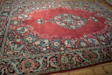 Vintage Arak carpet's central floral medallion and intricate borders seen from an angled perspective.