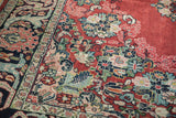 Detailed view of the vintage Arak carpet's corner, showcasing the low pile and dense floral patterns.