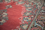 Close view of the vintage Arak's low pile, highlighting the ruby red field and detailed floral border.