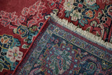Folded corner of a vintage Arak rug showing the hand-knotted back, original fringe, and red selvage.