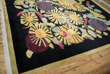 Corner detail of Art Deco Indian rug with black field, yellow sunflowers, and golden side selvage.