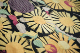 Plush pile close-up of Art Deco style golden sunflowers and textured purple starburst motif.