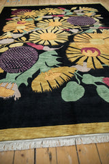 Plush pile vintage Indian Art Deco carpet with gold sunflowers, mauve blooms, green leaves, black field, and fringe.