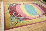 Contoured carving on the scalloped cochineal red and saffron of this vintage Indian rug.
