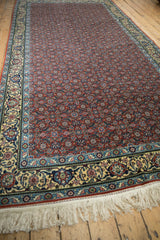 Angled view of a vintage Bulgarian runner's rust Herati field, detailed Samovar border, and fringe.