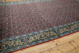 Angled view of the vintage runner's rust Herati field alongside its detailed buttercream and blue border.