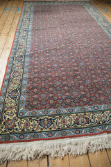 Corner view of a vintage Tabriz runner with a detailed Samovar border and full white fringe.