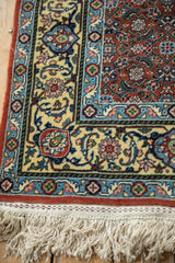 Vintage Bulgarian runner corner showing the buttercream Samovar border, rust field, and ivory fringe.
