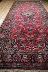 Rich red field and navy border of the Dargezine runner with intricate floral patterns.