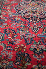 Dargezine runner's plush cherry red pile with intricate navy, blue, green, and pink floral bouquets.