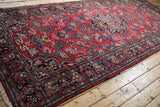 Hand-knotted Persian Dargezine runner, cherry red floral field, navy border, intact selvage.