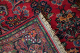 Fringed corner and multicolor patterned borders of a vintage hand-knotted Persian Dargezine runner.