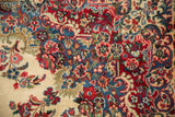 Floral sprays and curvilinear motifs in cherry red, sky blue, and ivory tones on a vintage Kazvin rug.
