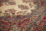 Dense floral sprays in cherry red, sky blue, and ivory on a vintage Persian Kazvin rug.