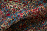 Detail of Vintage Kerman carpet, showcasing its full pile and intricate raspberry floral sprays against sky blue.