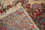 Vintage Kerman carpet corner, showing woven foundation, intact selvage, and colorful floral border.