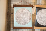 Side-by-side comparison of the light aqua and black mini moon chart art prints.