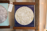 East corner detail of navy and ivory moon chart art print and walnut rod.