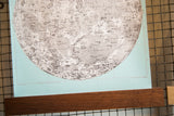 Detailed printing and texture of the light aqua canvas moon chart with its walnut wood rod.