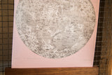 Close-up of the moon chart's intricate map on textured, ballerina pink artist canvas.