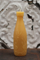 Wick and embossed dainty leaves and citrus blossoms on the beeswax bottle candle.