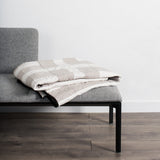 Handmade Louise Gray Quilt No. 7 folded, with white and tan grid pattern.