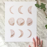 Soft beige watercolor moon phases on bottom corner of Katelyn Morse art print with hand.