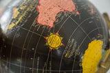 Yellow starburst label on the Mid Century Cram's 12-inch black globe.