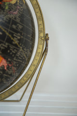 Mid Century Cram's black globe: close-up of aged brass meridian and hinge.