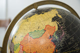 Mid Century Cram's black terrestrial globe detail, colorful Asia and black oceans.