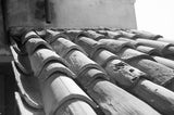 Black and white photograph capturing textured, curved terracotta roof tiles in Florence.
