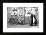 Black framed Florence Italy street photograph showing bicycles and a person walking.