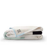 Louise Gray No. 2 Quilt, folded, light blue trim with black LG logo.