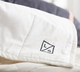 Black embroidered L/G logo detail on a cream Louise Gray Quilt No. 6.